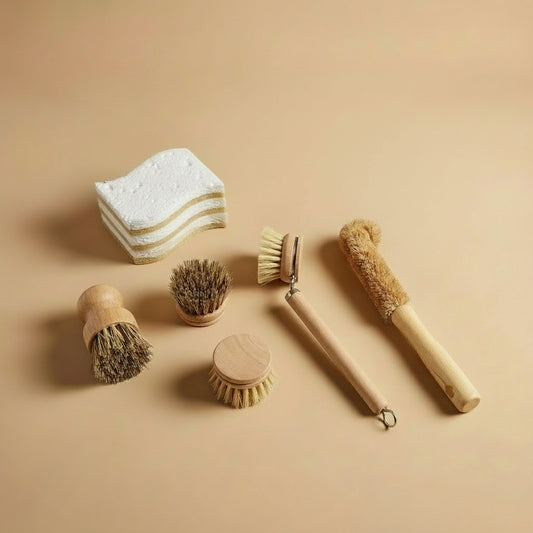 Nachhaltiges Spülset mit Holz-Spülbürsten, Topfbürsten und kompostierbaren Spülschwämmen auf beigem Hintergrund