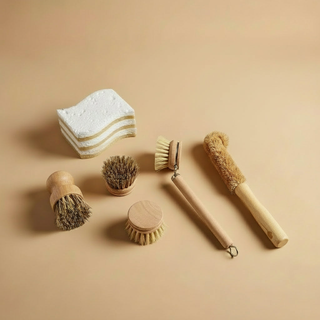 Nachhaltiges Spülset mit Holz-Spülbürsten, Topfbürsten und kompostierbaren Spülschwämmen auf beigem Hintergrund