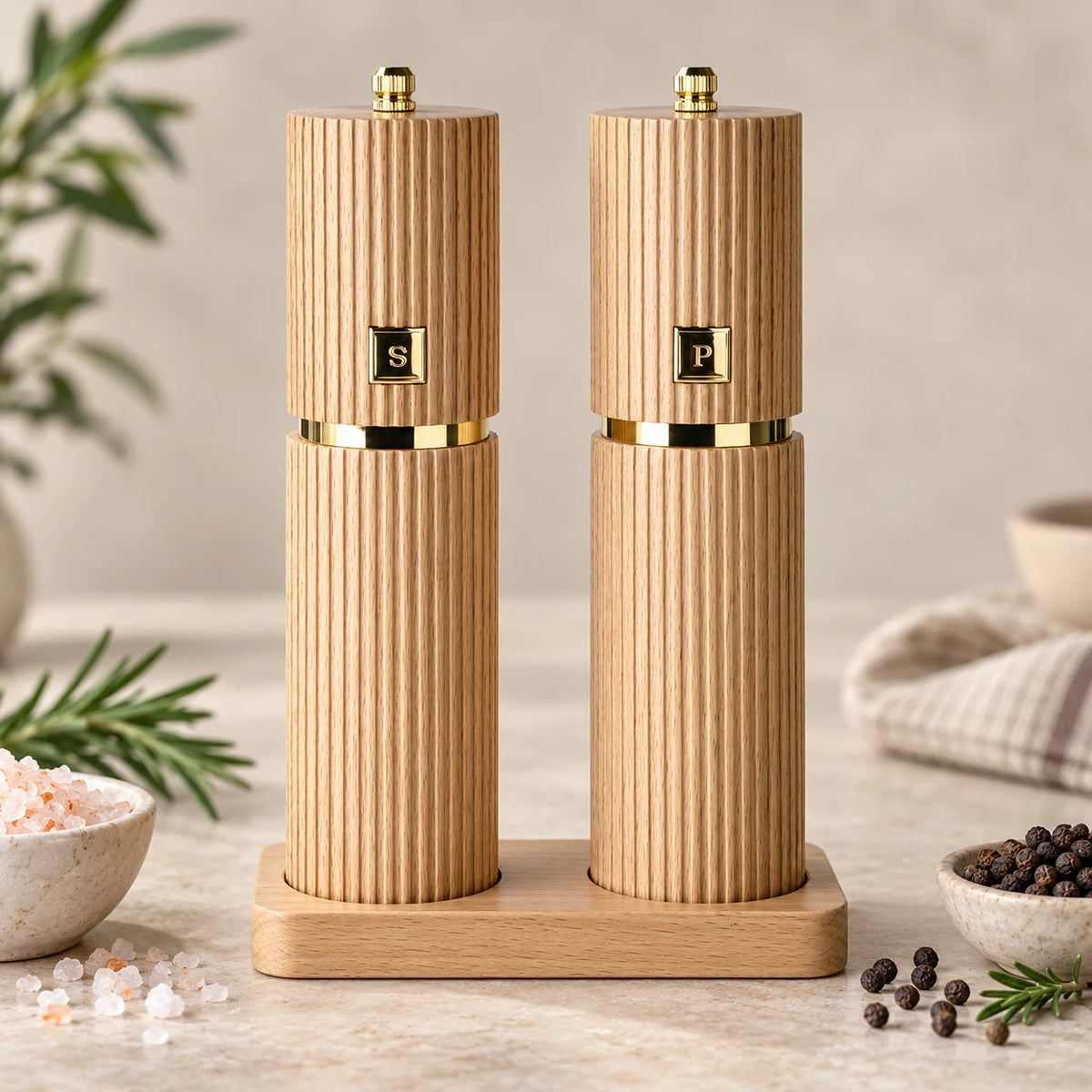 Salz- und Pfeffermühlen Set aus Buchenholz mit goldfarbenen Details und passendem Holzhalter.