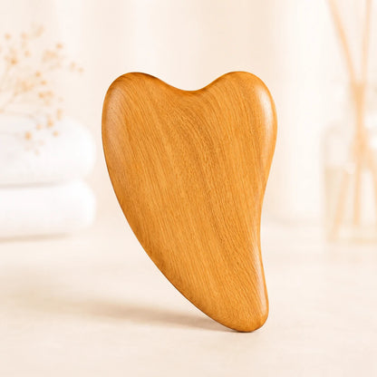 Sandelholz Gua Sha Massage Tool aus Holz auf hellem Wellness Hintergrund